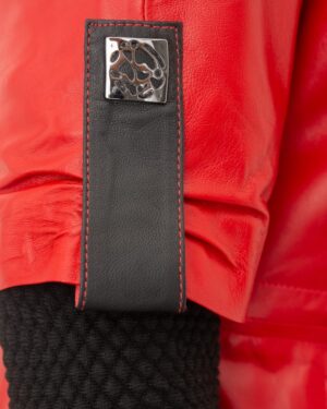 Czerwona kurtka skórzana damska z czarnymi akcentami i ozdobnym zapięciem na rękawie