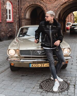 Męski kożuch w czarnym kolorze z futrzanym kołnierzem i metalowymi detalami, idealny na zimowe dni