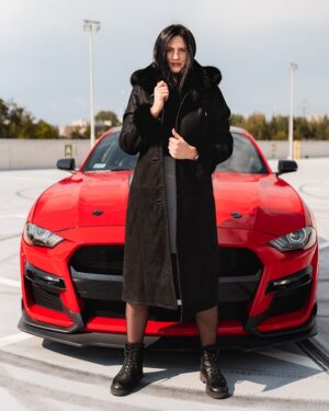 Kożuch damski w czarnym kolorze, z futrzanym kołnierzem i długim krojem, idealny na zimowe dni