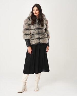 Futro naturalne w odcieniach szarości z kapturem, elegancko dopasowane do czarnej spódnicy plisowanej
