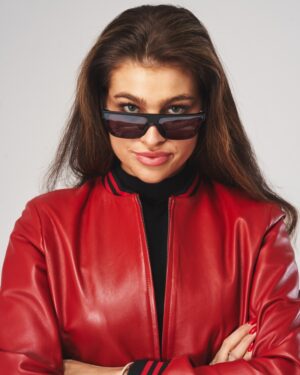 kurtka skórzana damska w czerwonym kolorze z czarnymi detalami i okularami przeciwsłonecznymi