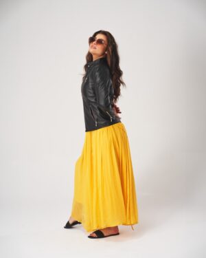 Kurtka skórzana damska w kolorze czarnym z zamkami i kołnierzem, stylizowana z żółtą spódnicą maxi
