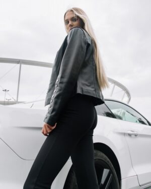 Czarna kurtka skórzana damska z przylegającym krojem i srebrnymi guzikami na rękawach